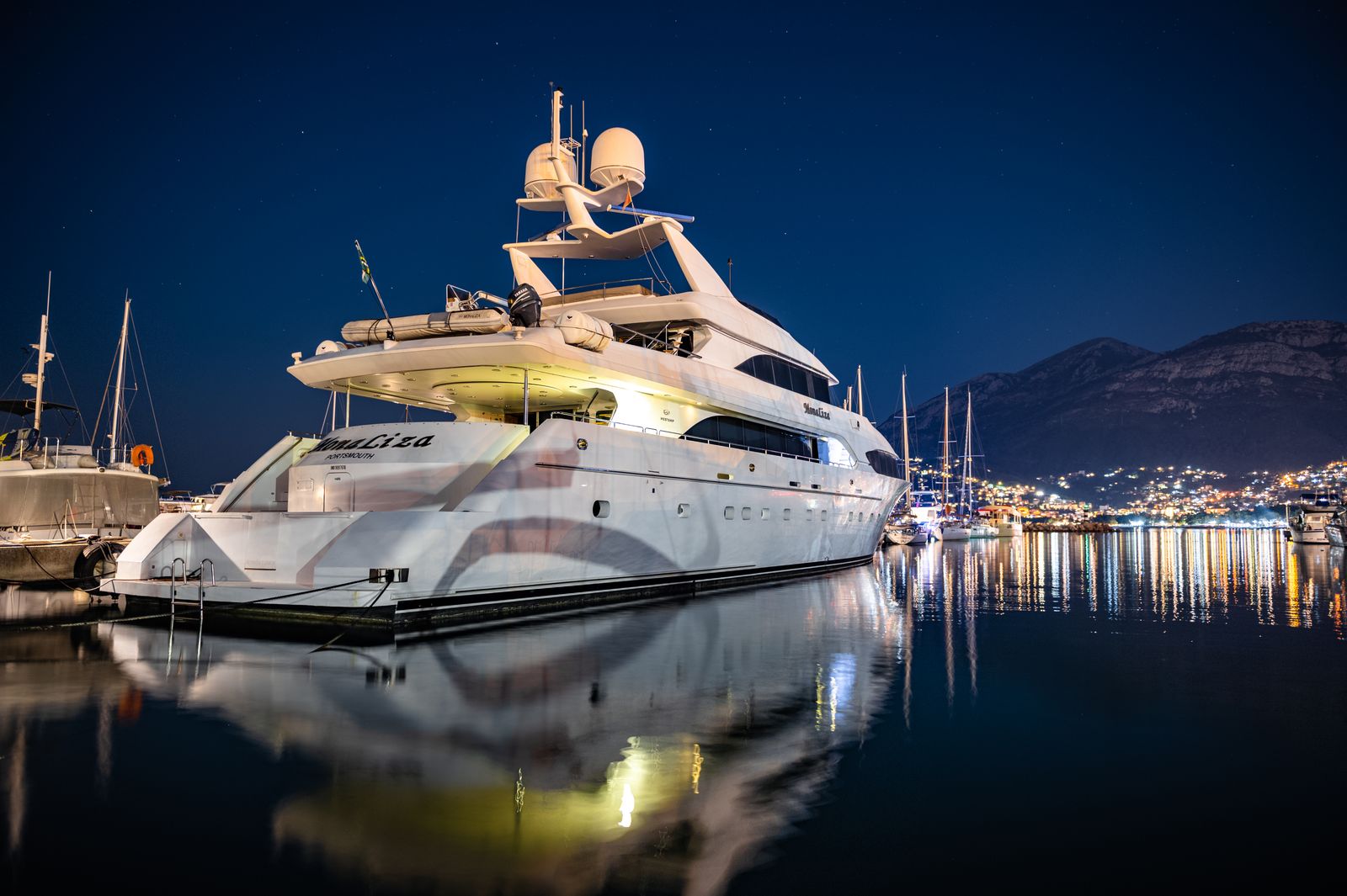 Vessel reflected in the water of a harbor at night